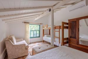 1 Schlafzimmer mit 2 Etagenbetten und einem Stuhl in der Unterkunft Camburi 5 quartos com piscina natural in Camburi