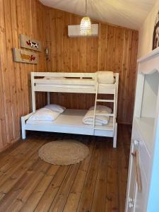 Etagenbett in einem Zimmer mit Holzwänden in der Unterkunft Maison de vacances à Petit Piquey, entre Bassin et Océan in Lège-Cap-Ferret