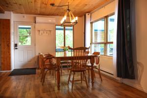 a dining room with a wooden table and chairs at Chalet Vallée Bras-du-Nord I in Saint-Raymond