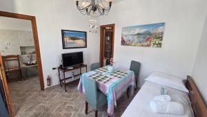 a room with a table and a bed and a television at Comfort and unparalleled view in Kóronos