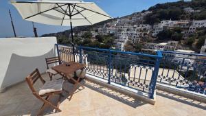a table and chairs on a balcony with an umbrella at Comfort and unparalleled view in Kóronos