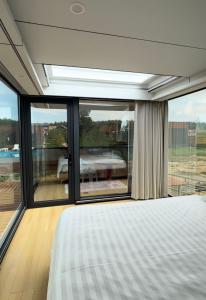 a bedroom with a bed and a large window at АТЫРАУ Авенью in Zhezdi