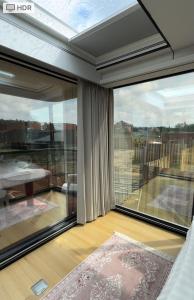 a room with a large window and a balcony at АТЫРАУ Авенью in Zhezdi