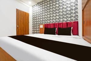 a bedroom with a large bed with a red headboard at Super Hotel O Sunshine Villa in Nagpur