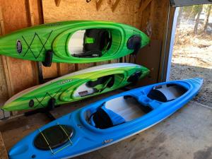 two kayaks are sitting next to a wooden wall at Chalet De l'Escapade hot tub Lakeview kayaks in Entrelacs
