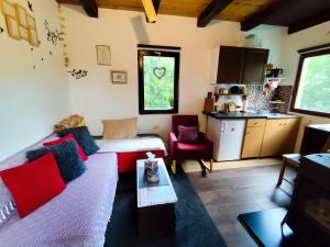 a living room with a couch and a kitchen at UNDER THE GREEN ROOF in Blaževića Dol