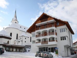 a white building with a wooden roof and a church at Apartment in Leogang near Ski Slopes in Leogang +31 photos