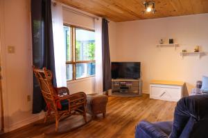 a living room with a couch and a tv at Chalet Vallée Bras-du-Nord I in Saint-Raymond