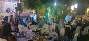 a group of people sitting around tables at a wedding at Κτήμα ΓΟΥΡΔΟΎΠΗ Georgιο in Lalióti +36 photos