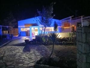 a night view of a building with blue lights at Κτήμα ΓΟΥΡΔΟΎΠΗ Georgιο in Lalióti