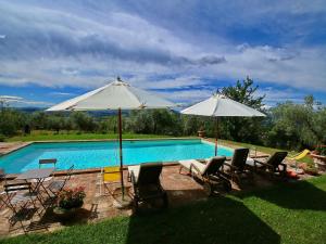 two umbrellas and chairs next to a swimming pool at Farmhouse in Todi with Pool & Theater Nearby in Chioano +19 photos