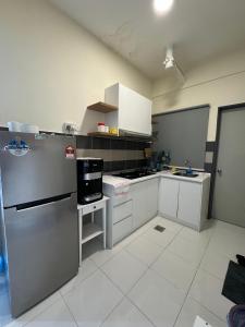 a large kitchen with white cabinets and appliances at Damai Vacation Stay 7 pax 3 Free Parking in Shah Alam +2 photos