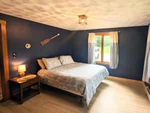 a bedroom with a bed and a table and a window at Rustic 3 bedroom Cottage in The Western Maine Mountains in Waterford Flat