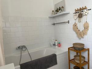 La salle de bains est pourvue d'une baignoire blanche et de carrelage blanc. dans l'établissement Spacieuse villa dans les pins, à Marseille 14 autres photos