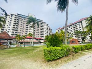 a park with palm trees and a large building at FA Seaview Glory Beach Resort in Port Dickson