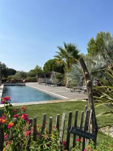 a garden with a fence and a swimming pool at Les Lodges Saint Pierre in Cap d'Agde
