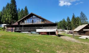 a large wooden building with windows on a field at La Belle Vie in Vartop
