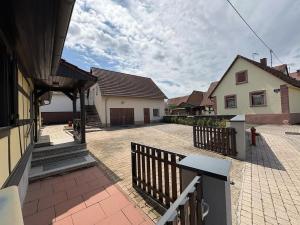 a courtyard with two houses and a fence at Charming Alsatian house in Beinheim