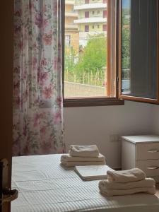 a room with two beds and a window with towels at K Bougainville Albania in Orikum