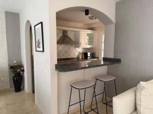 a kitchen with a counter and stools in a room at La Caleta Luxury Seaside Villa with 3 Bedrooms and Private Pool in Adeje