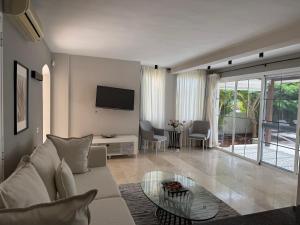 a living room with a white couch and a glass table at La Caleta Luxury Seaside Villa with 3 Bedrooms and Private Pool in Adeje