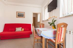 - un salon avec un canapé rouge et une table dans l'établissement Apartment Darko, à Rovinj