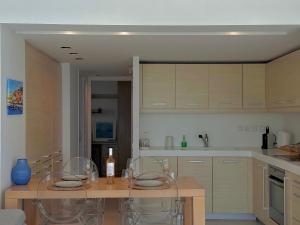 Dream View Vouliagmeni في أثينا: مطبخ مع طاولة مع كراسي وقمة كونتر +9 صور