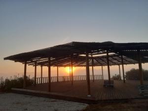 a pavilion with the sunset in the background at Mama Adama, Alpaca Farm And B&B in Grândola