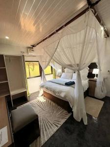 a bedroom with a large bed with a canopy at Austin's Oasis Apartment in Livingstone