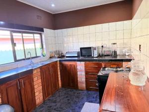 a kitchen with wooden cabinets and a counter top at Austin's Oasis Apartment in Livingstone