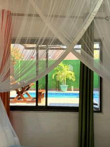 a bedroom with a window with a view of a pool at Austin's Oasis Apartment in Livingstone