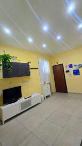 uma sala de estar com uma TV na parede em Casetta Delia em Palermo