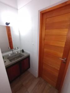 a bathroom with a wooden door and a sink at Casa Don Lopez in Mar Azul