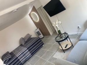 a bedroom with a bed and a table with a vase of flowers at Maisonnette indépendante in Morangis +2 photos