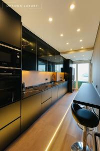a kitchen with black cabinets and a black bar stool at XIII 1d in Lisbon