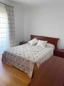 a bedroom with a large bed with a brown headboard at Apartamento amplio T3 Sao Bras de Alportel in São Brás de Alportel
