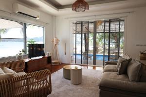 a living room with a couch and a table at Beachfront 2BR Villa w Private Pool in Koh Phangan