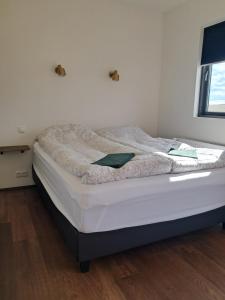 ein unverbautes Bett in einem Schlafzimmer mit Holzboden in der Unterkunft Guesthouse Klambrasel in Skogar