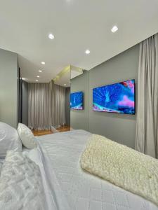 a bedroom with a large bed with two monitors on the wall at Top of the Alpha Duplex in Barueri