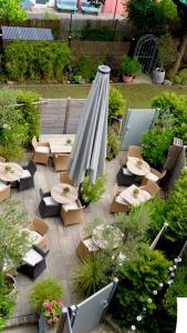 a patio with tables and chairs and a large umbrella at Hotel am Bergl in Schweinfurt