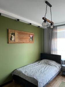a bedroom with a bed with a green wall at Moja Planeta in Białystok