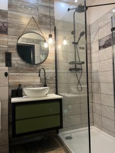 a bathroom with a sink and a shower with a mirror at Moja Planeta in Białystok +7 photos