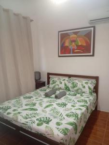 Malapasqua Island Cottage Holiday House : غرفة نوم مع سرير لحاف أخضر و أبيض