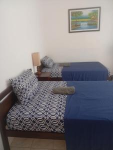 Malapasqua Island Cottage Holiday House : غرفة نوم بها سريرين وأريكة