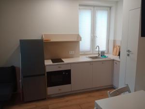a kitchen with white cabinets and a sink and a stove at Wojska Polskiego 18 in Braniewo
