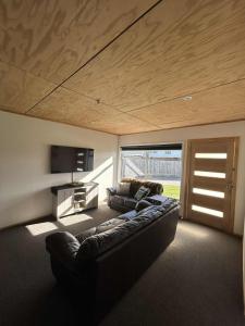 un salon avec un canapé et une télévision à écran plat dans l'établissement Lake Maraetai Escape, à Mangakino