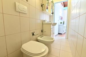 a white bathroom with a toilet and a sink at IzzHome Sea Style Apartment in Pula