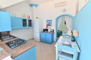 a kitchen with blue cabinets and a white refrigerator at IzzHome Sea Style Apartment in Pula +14 photos