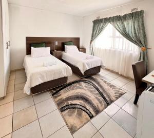 a bedroom with two beds and a window at White Hills Park - Apartment in Mthatha
