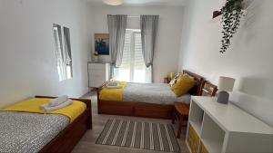 Un dormitorio pequeño con dos camas y un escritorio. en Soul Surfer, en Peniche
